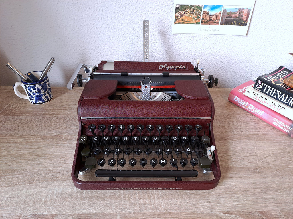 A serviced Olympia SM typewriter in dark burgundy red, front view